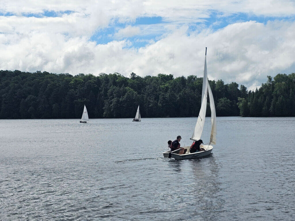 Three sailing dinghies on the lake.